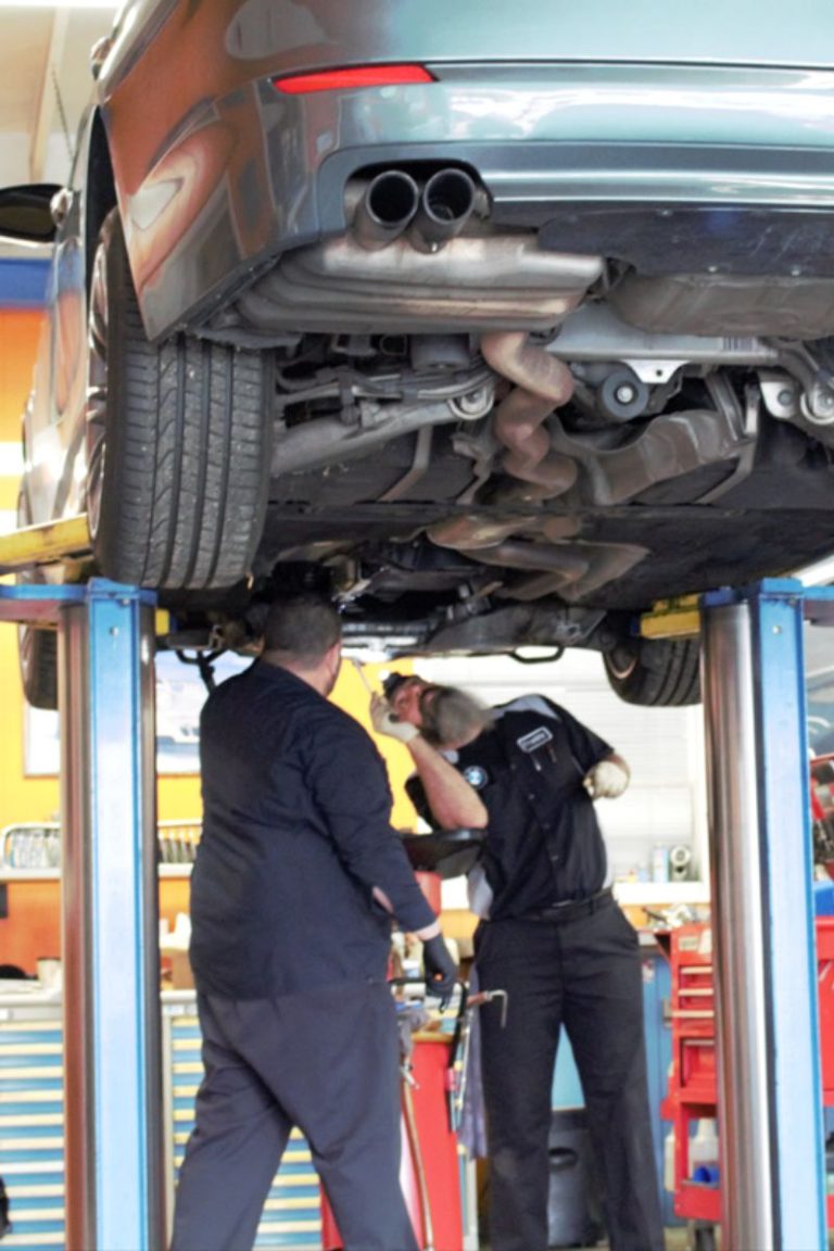 Technician working under a BMW on a lift at Bimmers Clinic